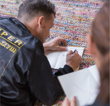 Man writing in a journal during a corporate wellness workshop