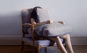 Girl under cushion sad