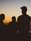 Silhouettes of men in caps