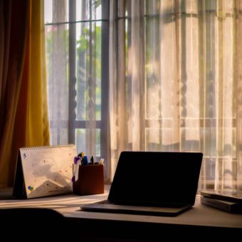 Online Therapy: A computer against curtains with soft light