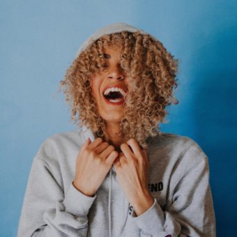 NDIS Therapist: A woman laughs on a blue background