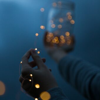 Hands float into the distance with refracted blue and yellow light