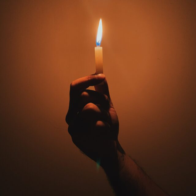 A hand holds a candle