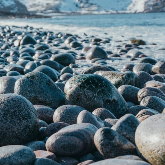 A medium shot of hundreds of smooth grey rocks in the outdoors