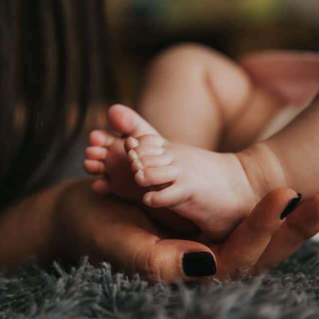Postnatal Depression: A mother touches her babies foot