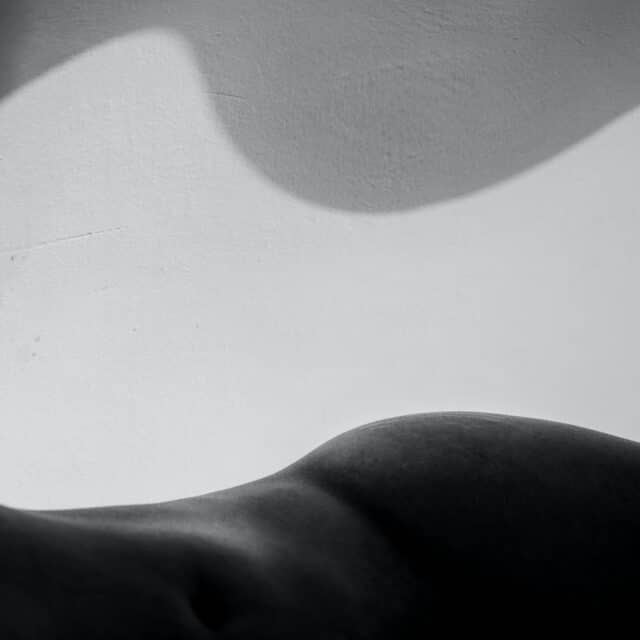 An abstract black and white image of a body and shadow