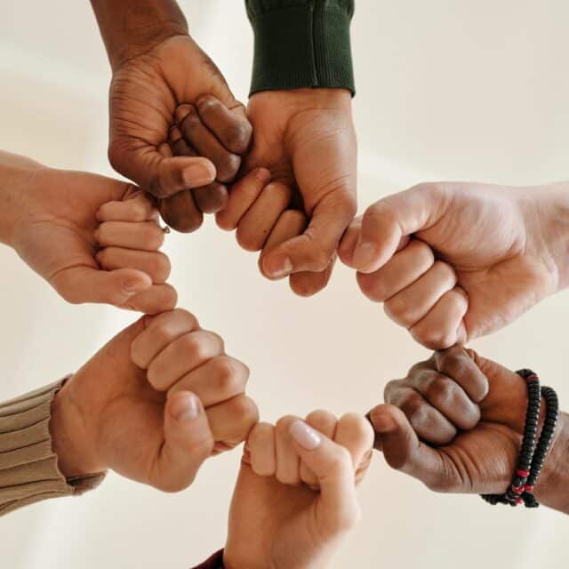 Internal Family Systems: A group of hands from different ethnicities fist bump