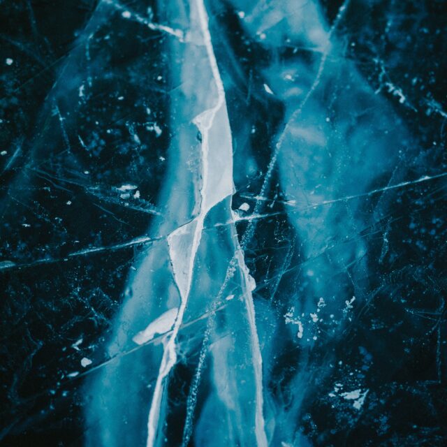 An up close image of cracked ice with colours of blue and white